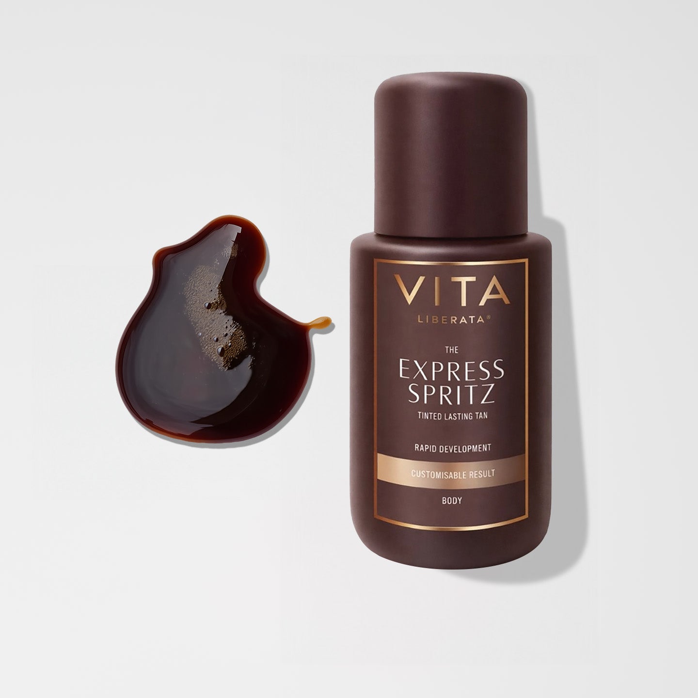 Vita Liberata Express Spritz tanning product with a droplet of brown liquid on a light gray background
